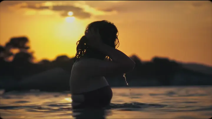 A silhouette in the sea at sunset